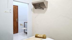a room with a bed and a light on the wall at Omah Sewu Sakura By Reccoma in Surabaya