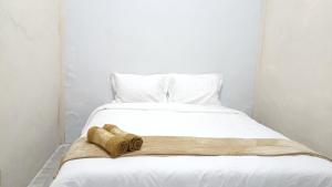 a white bed with two towels on top of it at Omah Sewu Sakura By Reccoma in Surabaya +31 photos