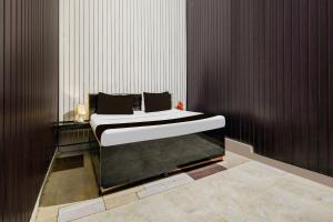 a bedroom with a bed in the corner of a room at Super Hotel Supreet Inn in Raipur