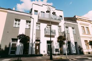 Un edificio blanco con un balcón en la parte superior. en Apartament ,,Loft pod piórem", en Nowy Sącz