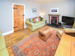 a living room with a couch and a fireplace at Hollin Bank Barn in Coniston