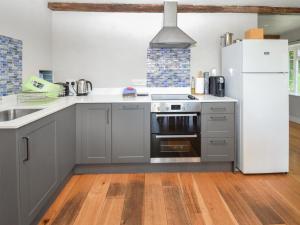 a kitchen with stainless steel appliances and a wooden floor at Hollin Bank Barn in Coniston +12 photos