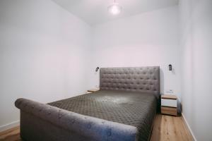 Cama en habitación con sofá en Apartament ,,Loft pod piórem", en Nowy Sącz
