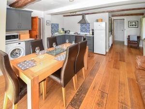 a kitchen and dining room with a wooden table and chairs at Hollin Bank Barn in Coniston