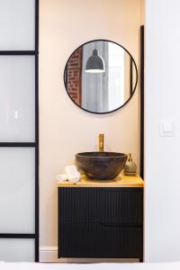 ein Badezimmer mit Waschbecken und Spiegel in der Unterkunft Uma Suites Fuencarral in Madrid
