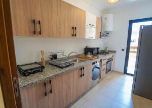 une cuisine avec un évier et un lave-vaisselle dans l'établissement Spacieux et luxueux appartement, à Marrakech 5 autres photos