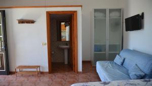 sala de estar con sofá azul y lavamanos en La Lonja 1, en Valle Gran Rey