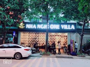 une voiture blanche garée devant un magasin dans l'établissement One Villa Hotel 2, à Hanoï