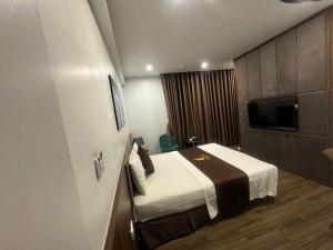 une chambre d'hôtel avec un lit et une télévision à écran plat dans l'établissement One Villa Hotel 2, à Hanoï