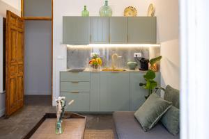 eine Küche mit Spüle und eine Couch in einem Zimmer in der Unterkunft Uma Suites Fuencarral in Madrid