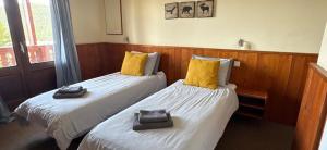 two beds with yellow pillows in a room at Hotel Belle Étoile in LʼHuez