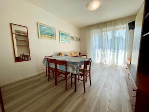 a dining room with a table and some chairs at Terraced house with private garden in Porto Santa Margherita di Caorle