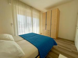 a bedroom with a bed and a dresser and a window at Terraced house with private garden in Porto Santa Margherita di Caorle