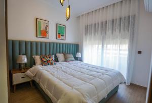 une chambre avec un grand lit et une fenêtre dans l'établissement Spacieux et luxueux appartement, à Marrakech