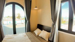 a bedroom with a bed with a large window at Chử - Phan Rang Villa & Tour in Phan Rang +102 photos