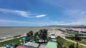 a beach with umbrellas and people on the beach at Chử - Phan Rang Villa & Tour in Phan Rang
