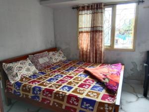 a bed with a quilt on it in a bedroom at Vanilla homestay in Vālpārai +3 photos