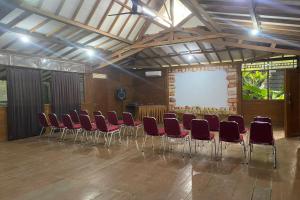 a conference room with red chairs and a screen at Santa Monica Resort in Ciherangsating +89 photos