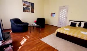 Un dormitorio con una cama y dos sillas. en Three Rivers Apartments - private free parking, self check-in, en Oradea