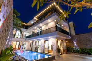 a villa with a swimming pool at night at Sunny Beach Villa in Danang