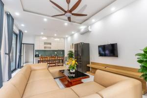 a living room with a couch and a tv at Sunny Beach Villa in Danang