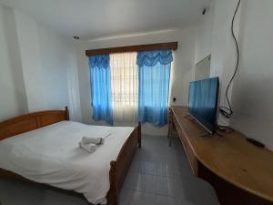 une chambre avec un lit, un bureau et une télévision dans l'établissement Ferionni 2 Apartelle & Suites near BGH, SM and Burnham Park, à Baguio