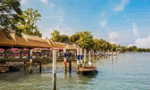 a boat sitting on the water next to a dock at Terraced house with private garden in Porto Santa Margherita di Caorle +17 photos