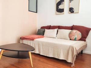 a couch in a living room with a table at Appartement lumineux à deux pas du port, avec terrasse in La Ciotat
