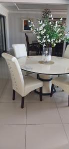 a dining room table with chairs and a vase of flowers at Blessing in East London +6 photos