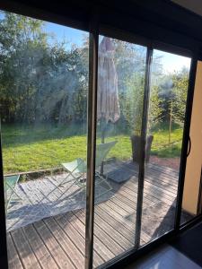a sliding glass door with a view of a deck at Maison avec jardin in Vendat
