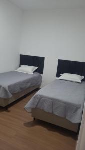 two beds sitting next to each other in a bedroom at Canto da Mantiqueira - Staffy House Extrema in Extrema +25 photos