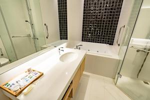 a white bathroom with a sink and a shower at Eusta Motel in Taichung