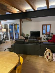 Una sala de estar con un sofá y un televisor. en Maison 10 pers Guillestre, en Guillestre