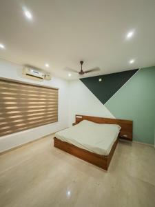 a bedroom with a bed in a room with a ceiling at Akshaya Homestay in Trichūr