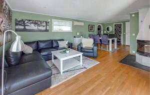 a living room with a couch and a table at 3 Bedroom Beautiful Home In Falkenberg in Stora Hansagård