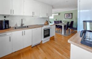 a kitchen with white cabinets and a dining room at 3 Bedroom Beautiful Home In Falkenberg in Stora Hansagård