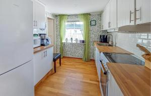 a kitchen with white cabinets and a wooden floor at 3 Bedroom Beautiful Home In Falkenberg in Stora Hansagård