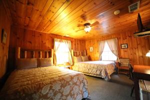 a bedroom with two beds in a wooden cabin at Grandview Lodge in Waynesville