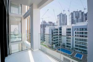 an apartment balcony with a view of a city at Escape 24 Lux 2BR Azizi Riviera in Dubai