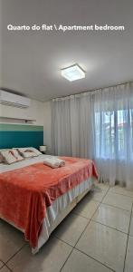 a bedroom with a large bed with a red blanket at Flat no Club Meridional de Carneiros - Bloco 4-2PP in Tamandaré +56 photos