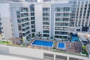 an aerial view of a building with a swimming pool at Escape 24 Lux 2BR Azizi Riviera in Dubai