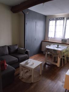 una sala de estar con un sofá y una mesa en Bel appartement a la campagne avec magnifique vue, en Sombernon