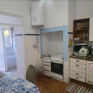 a small kitchen with a stove and a sink at Quarto individual in Mafra