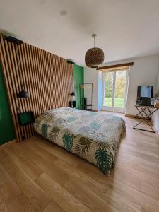 a bedroom with a bed and a television in it at Chambre au cœur de la nature 