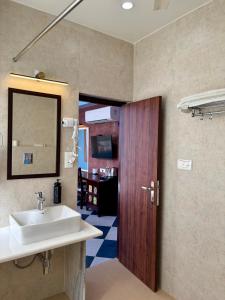 a bathroom with a sink and a wooden door at Kankariya Heritage in Jodhpur