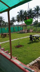 a park with picnic tables and a green field at Friendly homestay in Mysore +1 photo