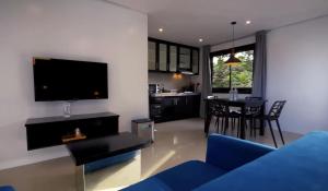 a living room with a blue couch and a tv at Harzel Apartelle - Suites and Serviced Apartments in Boracay