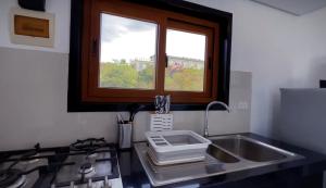 a kitchen with a sink and a window above a stove at Harzel Apartelle - Suites and Serviced Apartments in Boracay +28 photos
