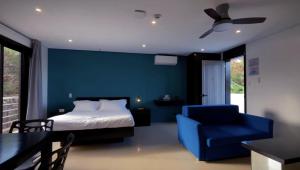 a blue bedroom with a bed and a blue chair at Harzel Apartelle - Suites and Serviced Apartments in Boracay