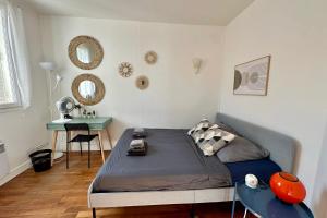 una camera da letto con un letto, un tavolo e degli specchi di Fontainebleau Centre a charming setting with generous volumes a Fontainebleau